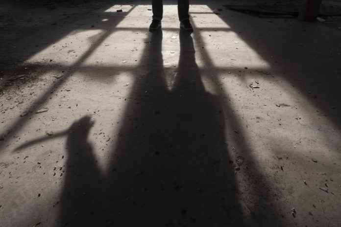 Shadow of a man holding large knife in his hand